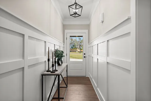 a view of a hallway with wooden floor and windows