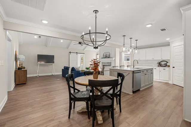 a view of a dining room and livingroom with furniture wooden floor a chandelier