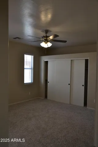a view of a room with a ceiling fan and a window