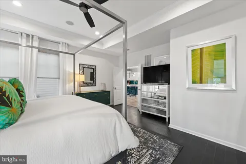 a spacious bedroom with a bed and a flat screen tv