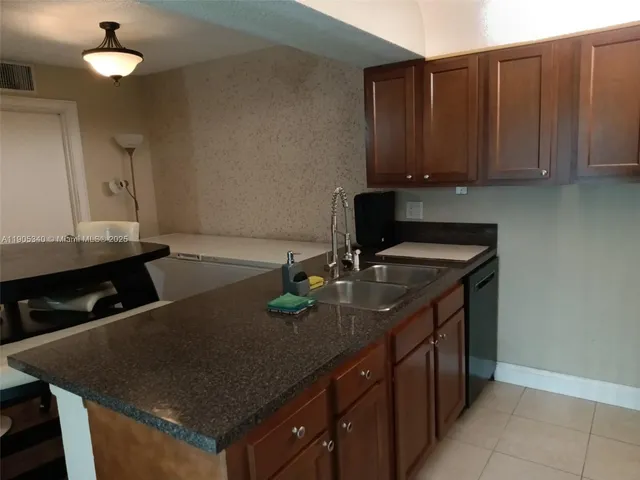 a kitchen with granite countertop a sink a stove and cabinets