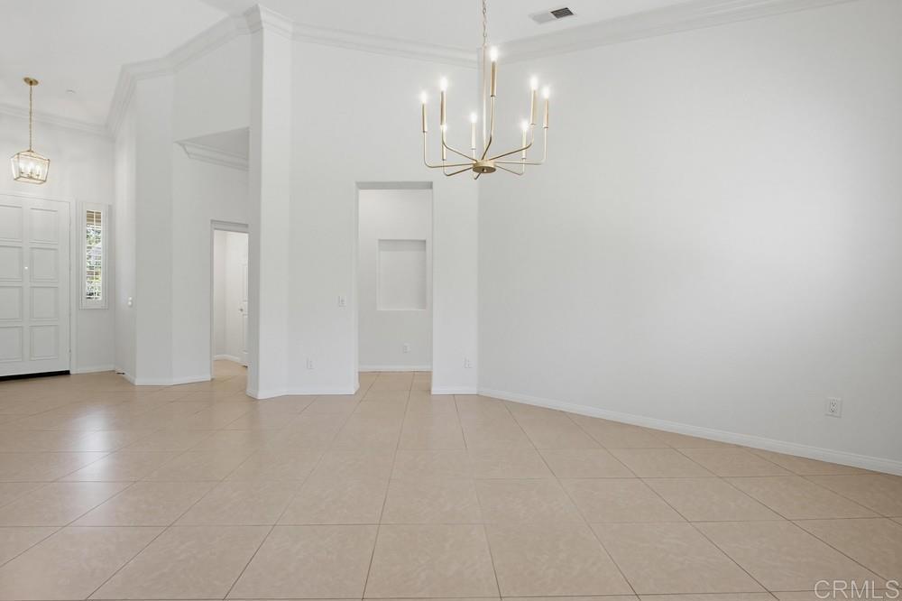 672 Inverlochy Drive Fallbrook, CA 92028 - Photo 15 of 75 a view of an empty room with wooden floor and a chandelier