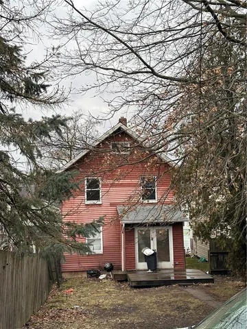 a front view of a house with a tree