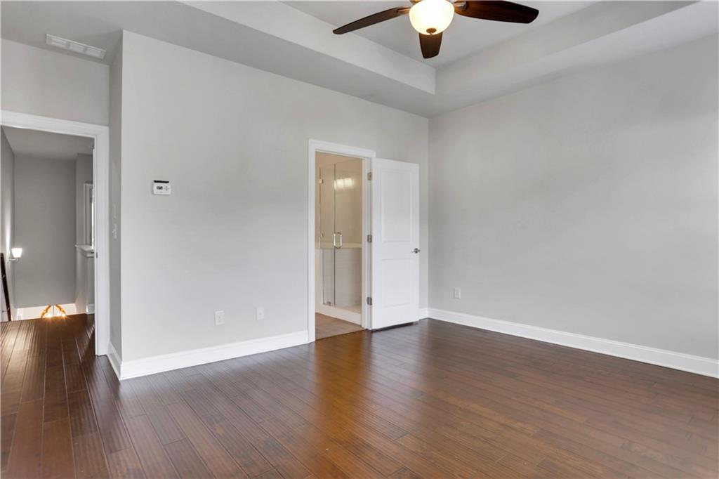 4103 Township Parkway Atlanta, GA 30342 - Photo 15 of 42 an empty room with wooden floor chandelier fan and windows