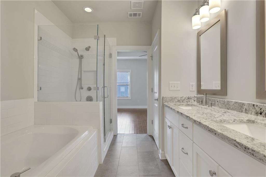 4103 Township Parkway Atlanta, GA 30342 - Photo 17 of 42 a bathroom with a granite countertop sink a bathtub and a mirror