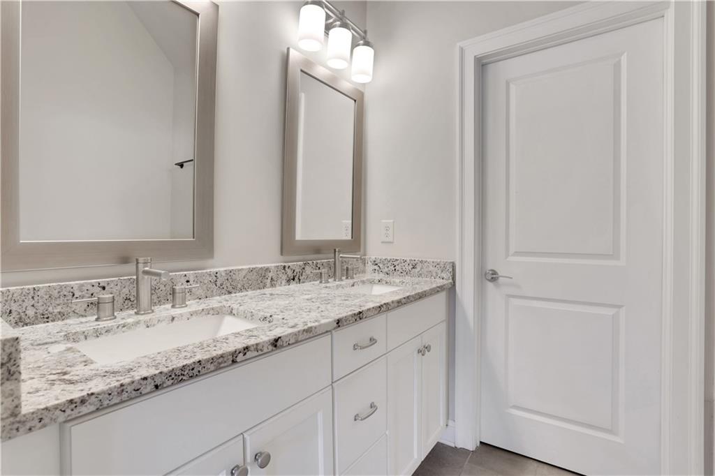 4103 Township Parkway Atlanta, GA 30342 - Photo 18 of 42 a bathroom with a granite countertop sink and a mirror