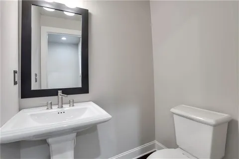 a bathroom with a sink a toilet and mirror