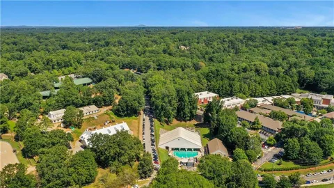 an aerial view of residential houses with outdoor space and trees