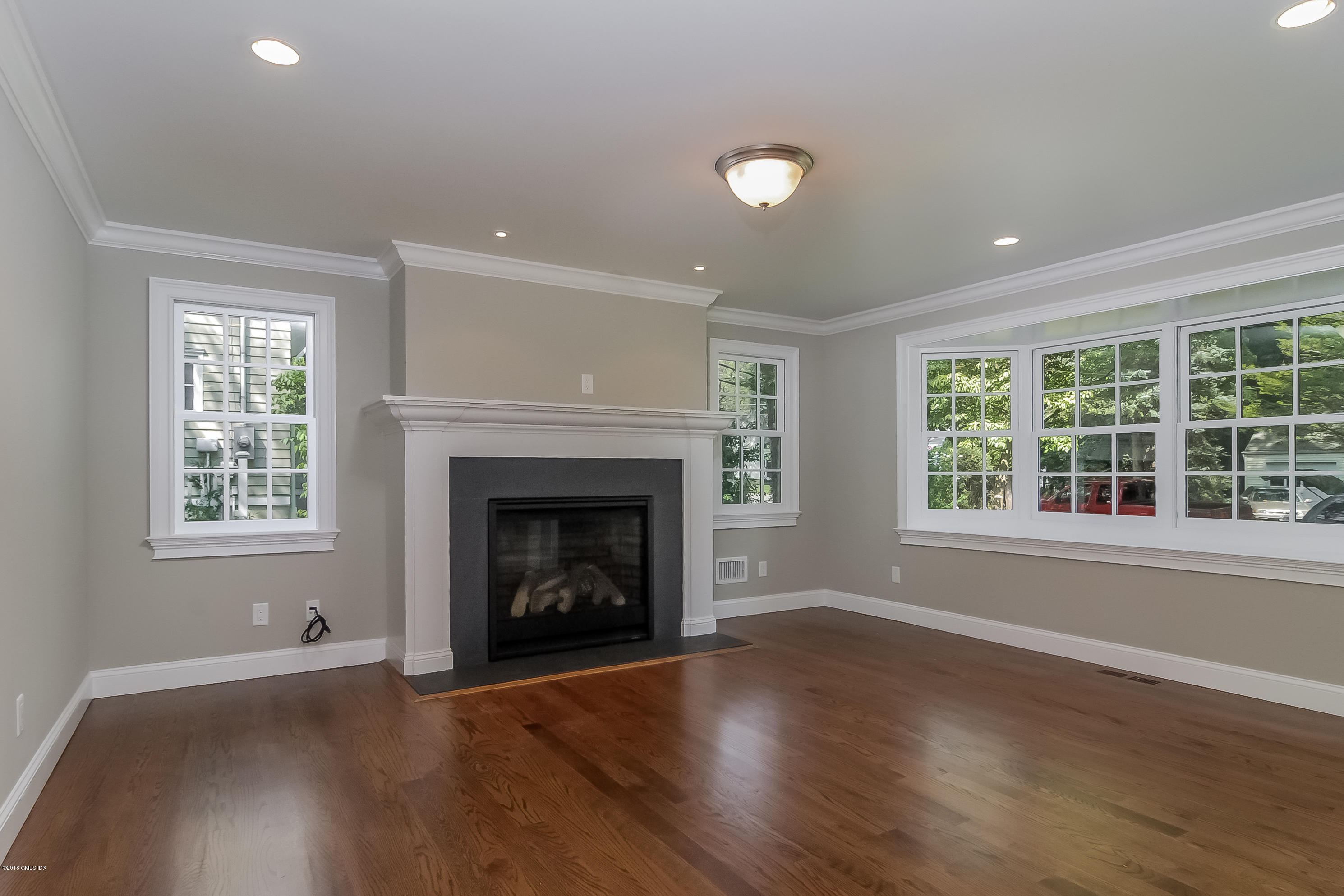 6 Dialstone Lane Riverside, CT 06878 - Photo 4 of 24 an empty room with wooden floor fireplace and windows