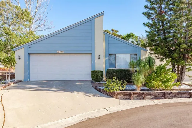 a front view of a house with a yard and potted plants
