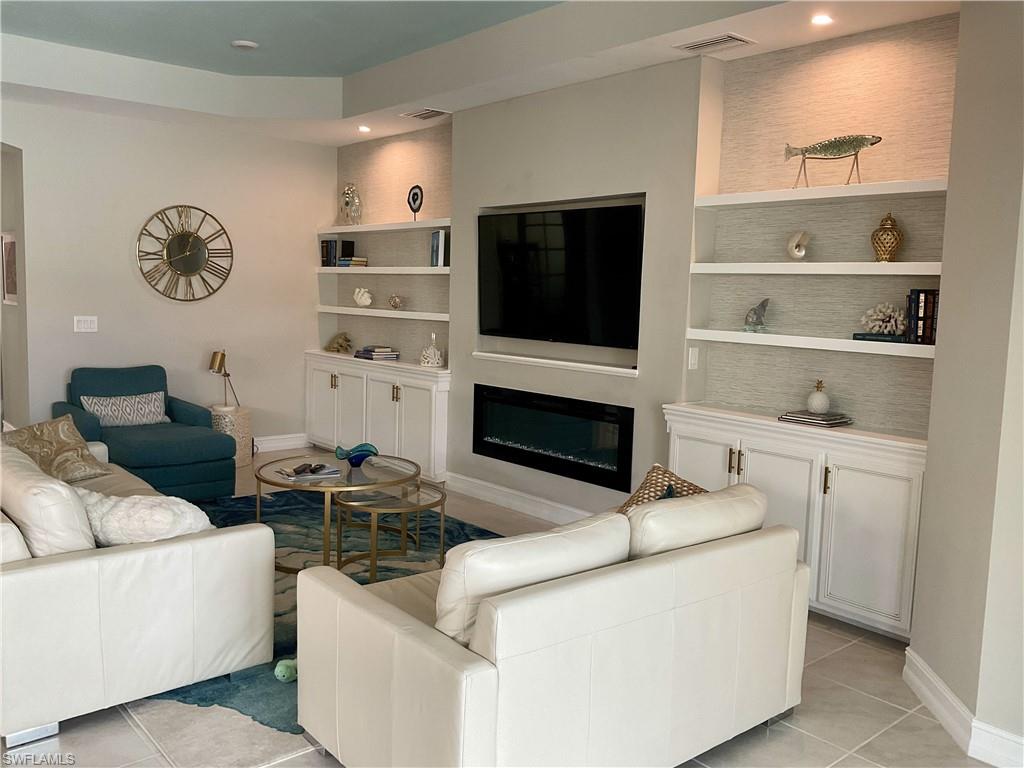 14614 Stillwater Way Naples, FL 34114 - Photo 15 of 47 a living room with furniture a flat screen tv and a fireplace