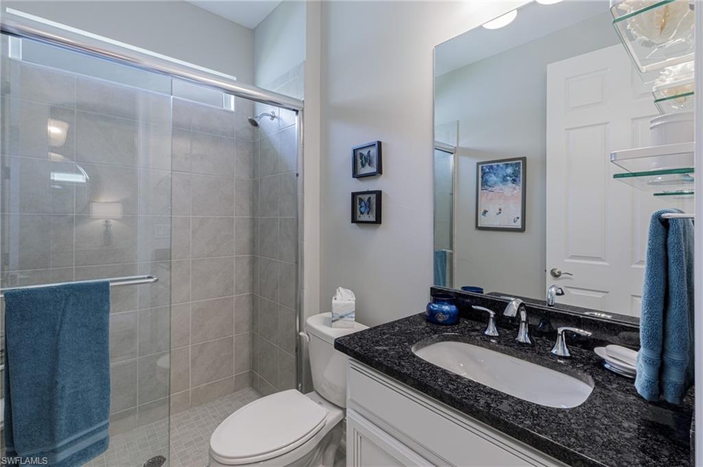 14614 Stillwater Way Naples, FL 34114 - Photo 27 of 47 a bathroom with a granite countertop sink toilet a mirror and shower