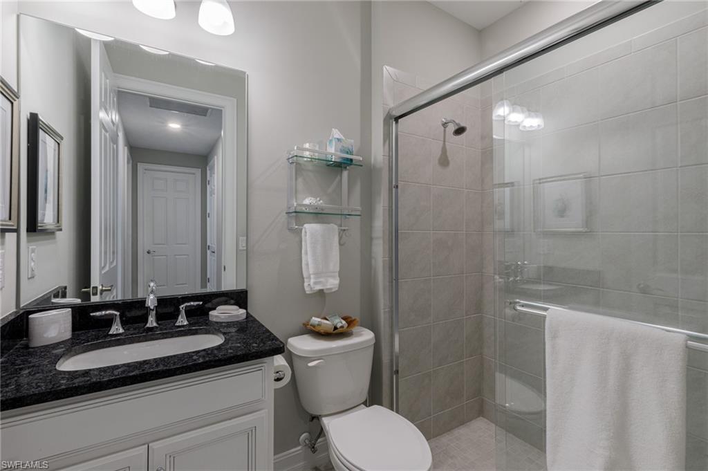 14614 Stillwater Way Naples, FL 34114 - Photo 30 of 47 a bathroom with a granite countertop sink toilet and shower