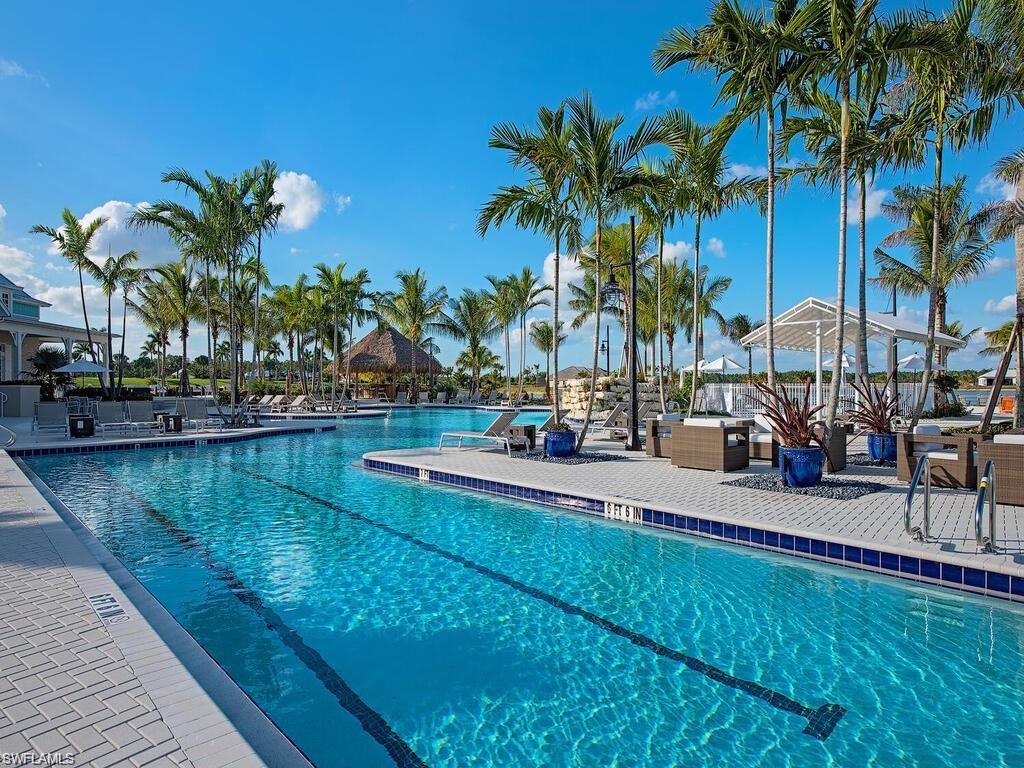 14614 Stillwater Way Naples, FL 34114 - Photo 40 of 47 a view of a swimming pool with a table and chairs