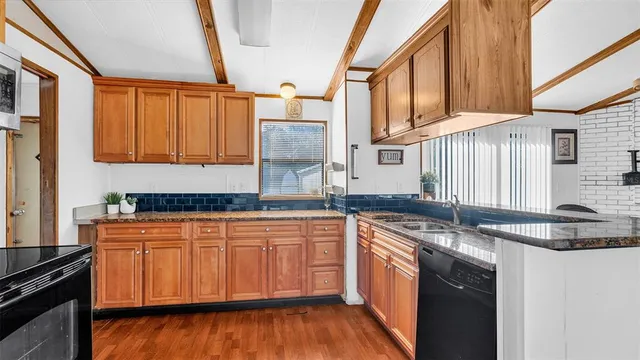 a kitchen with stainless steel appliances granite countertop a sink stove and cabinets