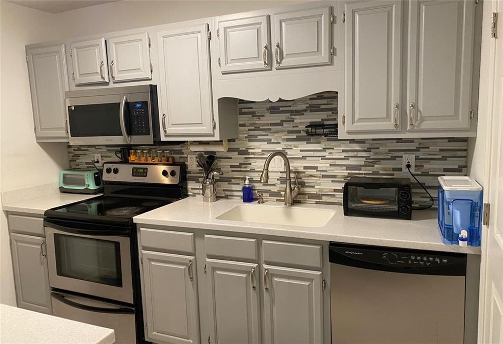 3934 Woodridge Way Tucker, GA 30084 - Photo 11 of 75 a kitchen with stainless steel appliances granite countertop a sink stove and microwave