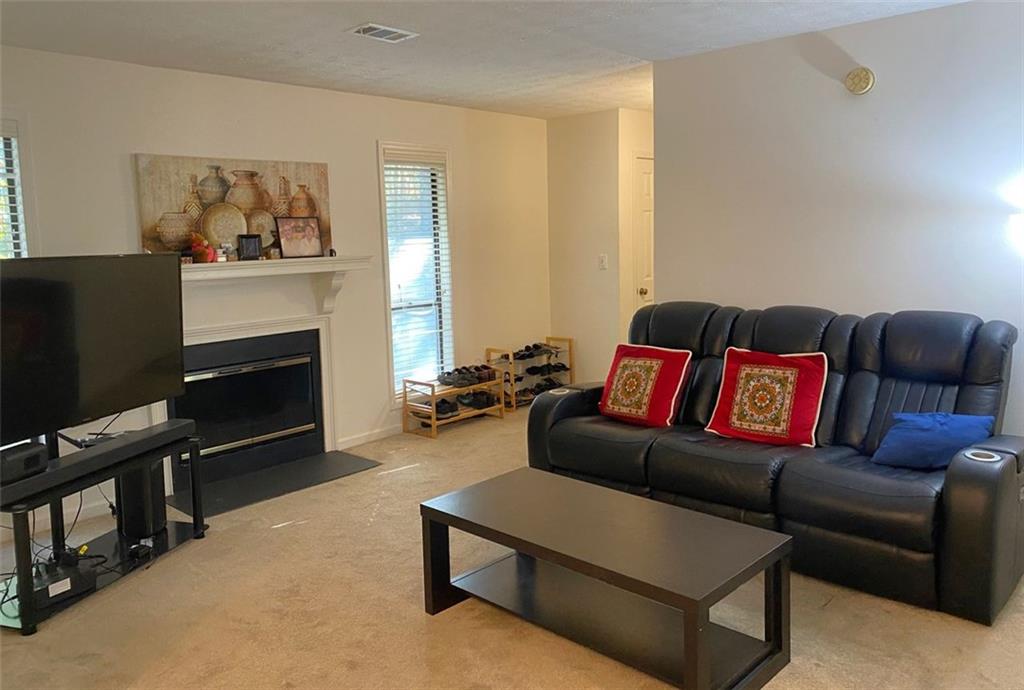 3934 Woodridge Way Tucker, GA 30084 - Photo 20 of 75 a living room with furniture a flat screen tv and a fireplace