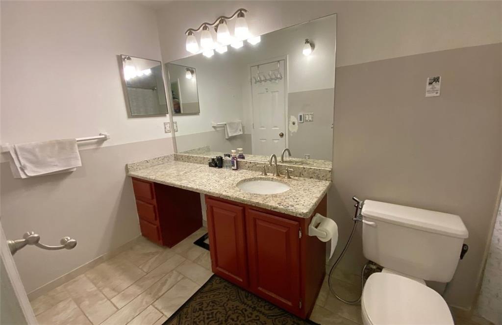 3934 Woodridge Way Tucker, GA 30084 - Photo 37 of 75 a bathroom with a granite countertop toilet sink and mirror