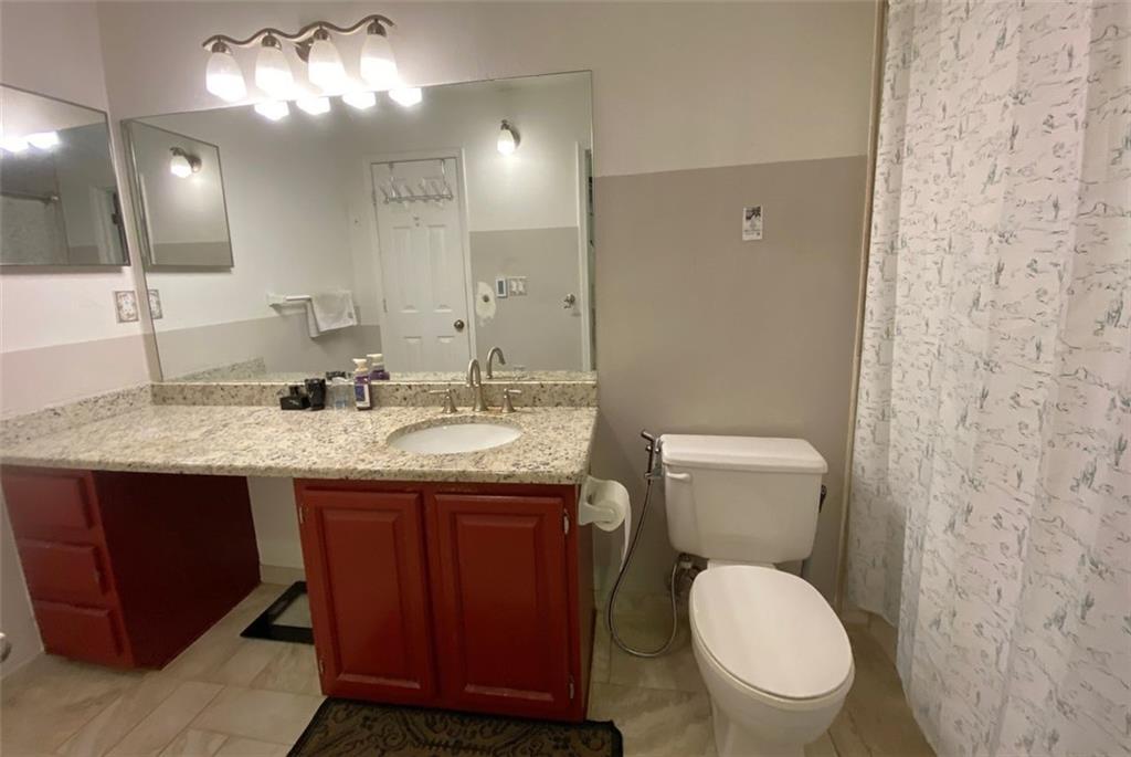 3934 Woodridge Way Tucker, GA 30084 - Photo 38 of 75 a bathroom with a granite countertop toilet sink and mirror