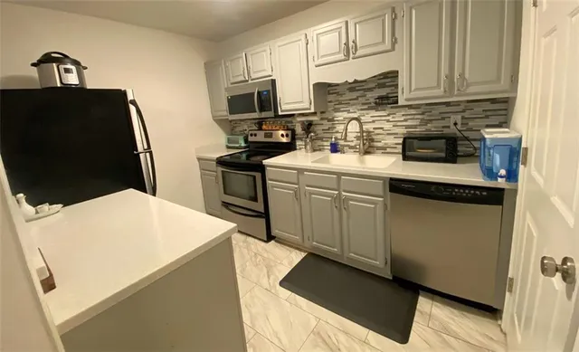 a kitchen with stainless steel appliances granite countertop a sink stove and microwave