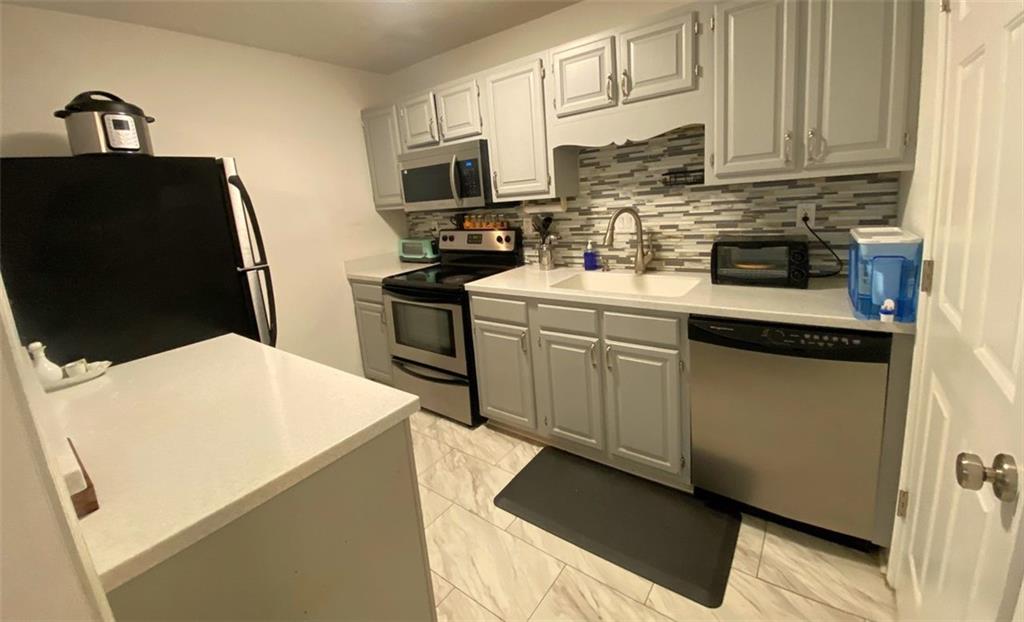 3934 Woodridge Way Tucker, GA 30084 - Photo 8 of 75 a kitchen with stainless steel appliances a stove refrigerator sink and cabinets