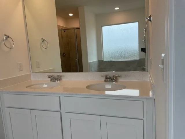 a bathroom with a double vanity sink and a mirror
