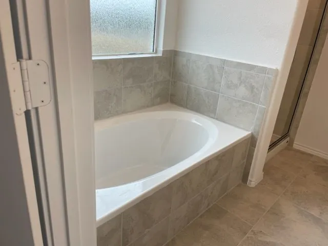 a bath tub sitting in a bathroom next to a window