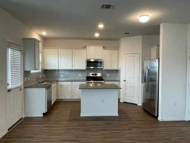 a kitchen with stainless steel appliances granite countertop a stove a sink and a refrigerator