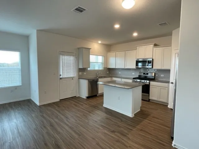 a kitchen with a refrigerator and a stove top oven