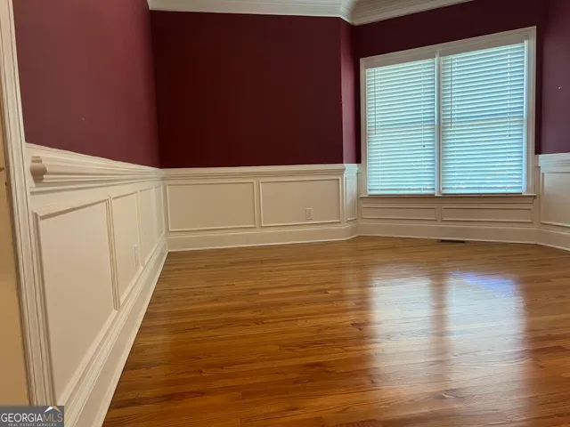 an empty room with wooden floor fireplace and cabinet