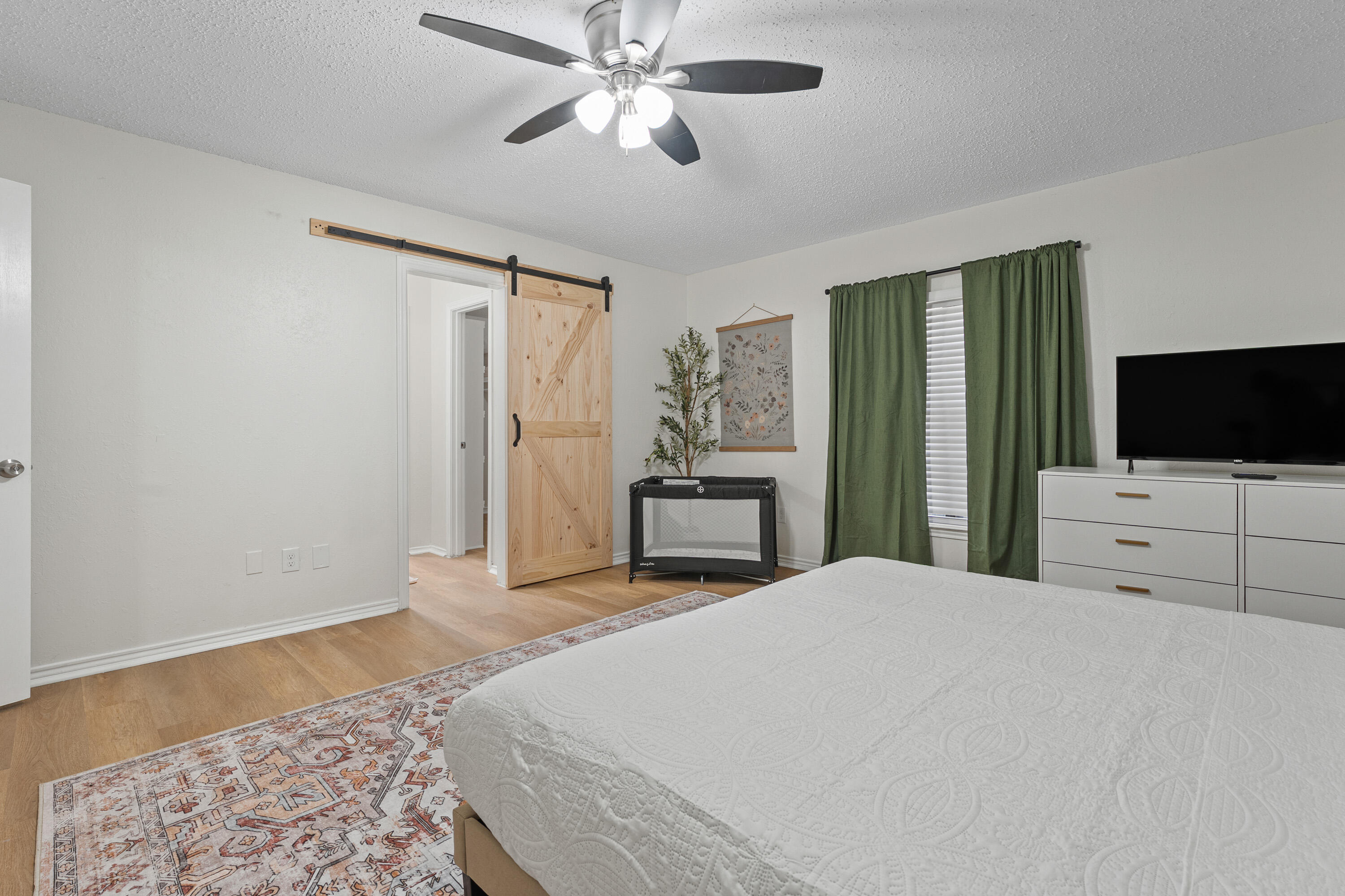 4510 77th Street Lubbock, TX 79424 - Photo 11 of 26 a bedroom with a bed and a flat screen tv