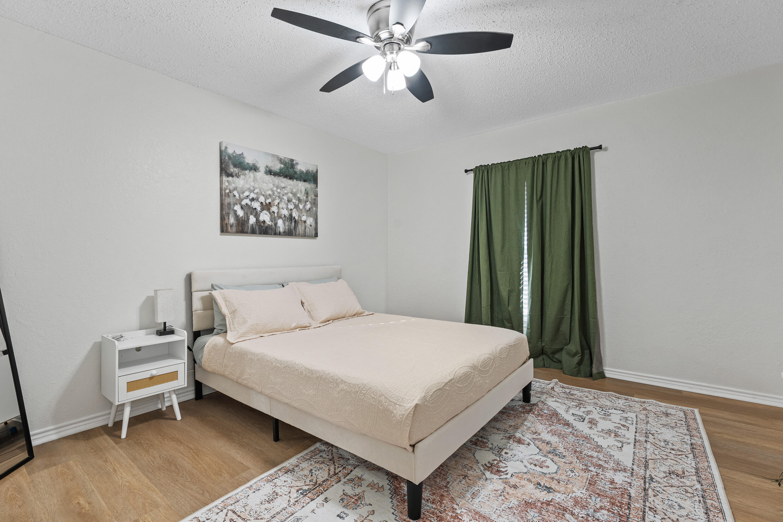 4510 77th Street Lubbock, TX 79424 - Photo 14 of 26 a bedroom with a bed and a chandelier