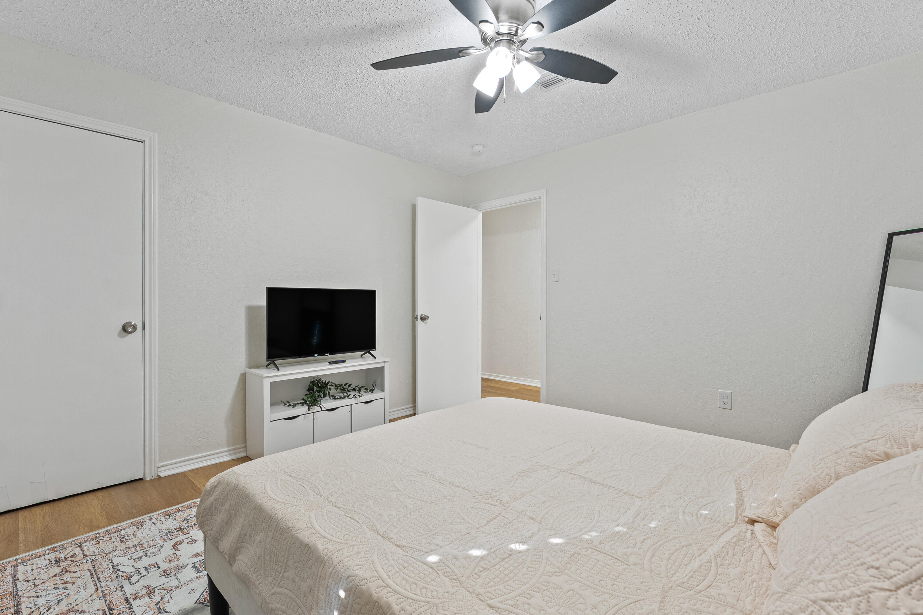4510 77th Street Lubbock, TX 79424 - Photo 15 of 26 a bedroom with a bed and a flat tv screen on wall