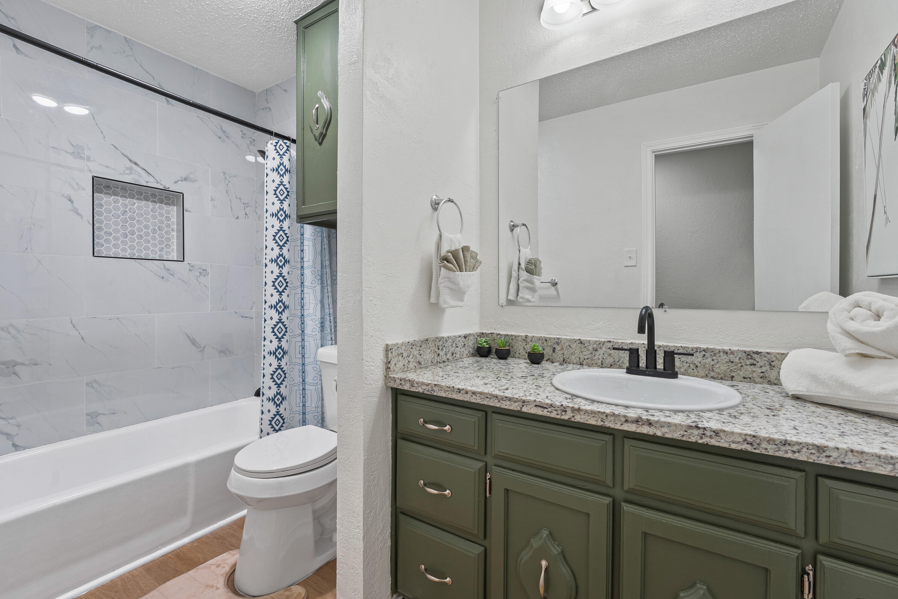 4510 77th Street Lubbock, TX 79424 - Photo 18 of 26 a bathroom with a granite countertop sink toilet and shower