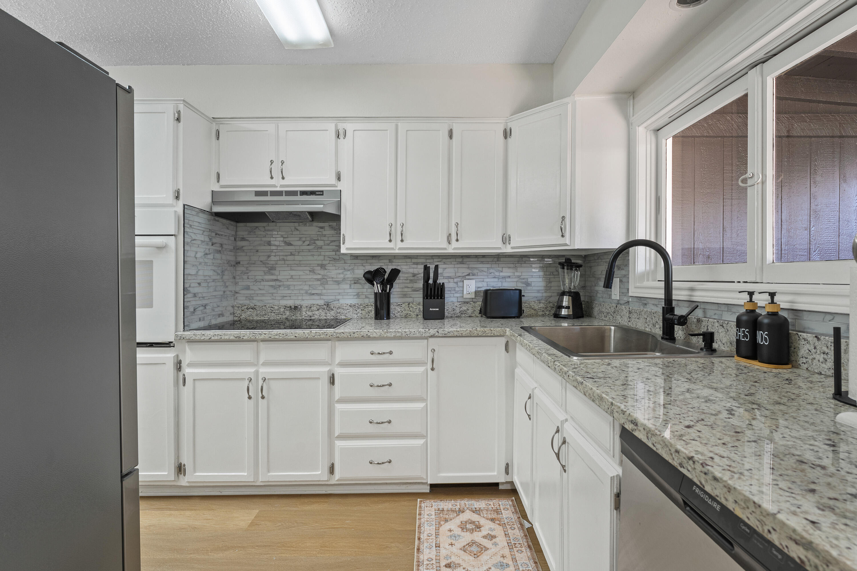 4510 77th Street Lubbock, TX 79424 - Photo 8 of 26 a kitchen with granite countertop a sink a stove and cabinets