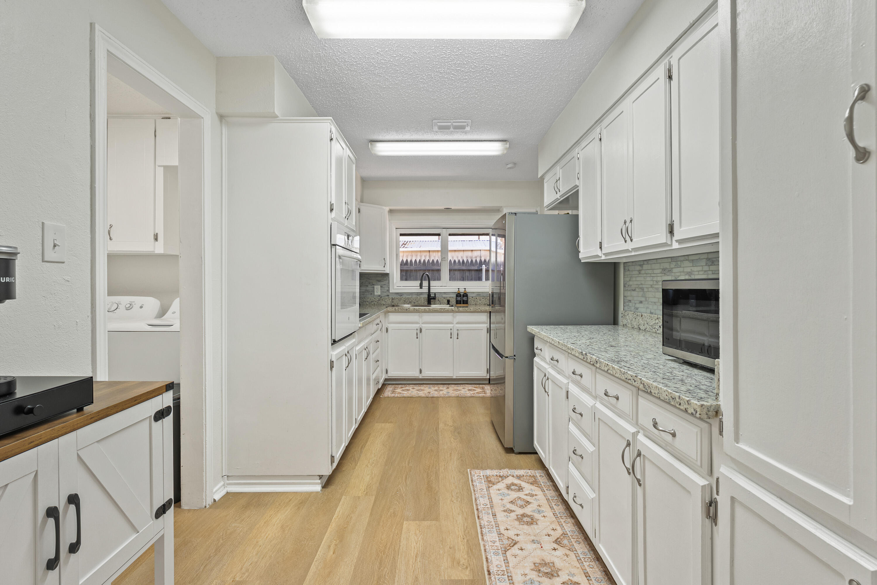 4510 77th Street Lubbock, TX 79424 - Photo 9 of 26 a kitchen with granite countertop a sink and cabinets