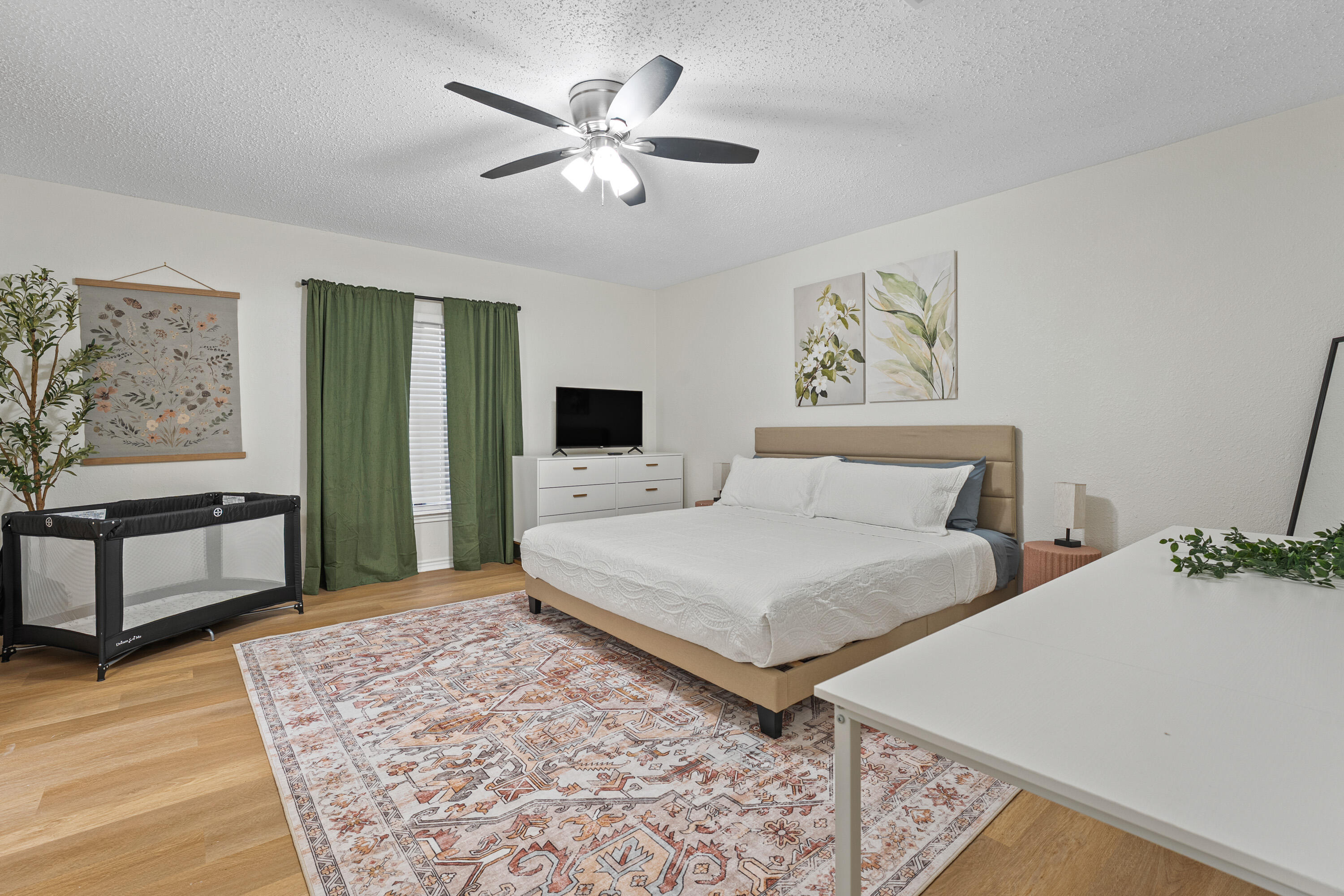 4510 77th Street Lubbock, TX 79424 - Photo 10 of 26 a bedroom with a large bed and a chandelier