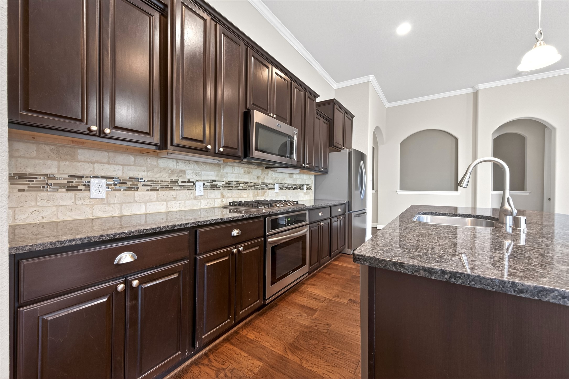 14 South Sawbridge Circle Spring, TX 77389 - Photo 18 of 45 a kitchen with stainless steel appliances granite countertop a sink stove and cabinets