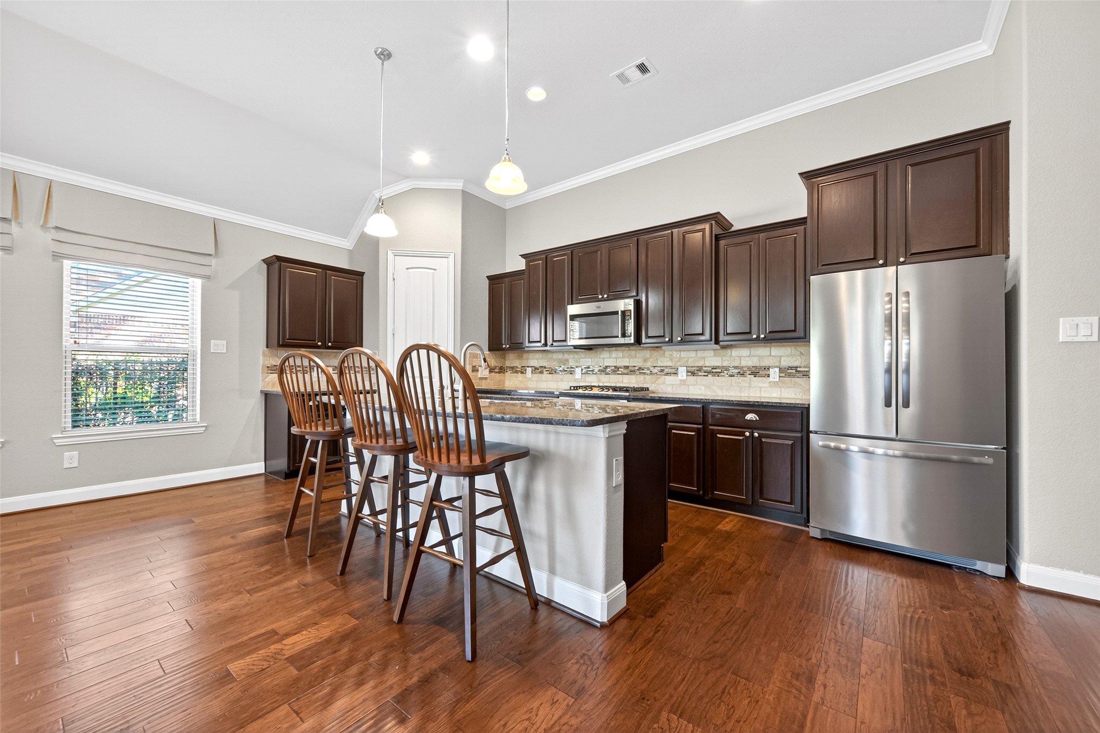 14 South Sawbridge Circle Spring, TX 77389 - Photo 20 of 45 a kitchen with stainless steel appliances a microwave a stove a refrigerator a sink a dining table and chairs