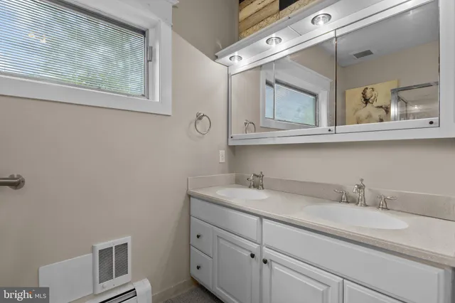 a bathroom with a granite countertop sink a toilet and shower