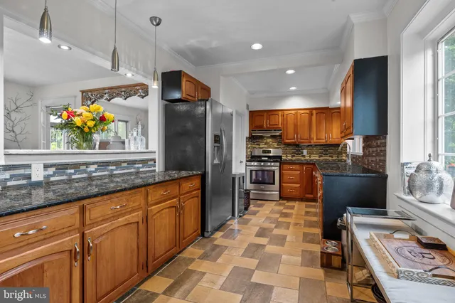 a kitchen with stainless steel appliances granite countertop a stove sink and cabinets