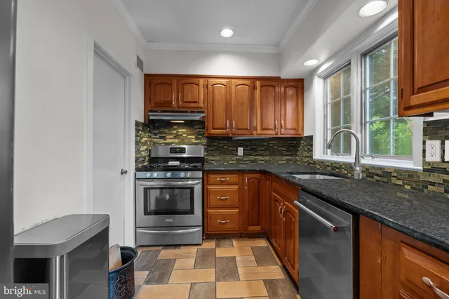 a kitchen with stainless steel appliances granite countertop a refrigerator and a sink