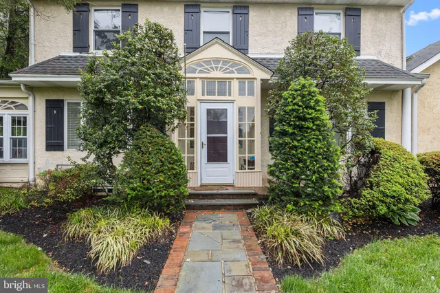 a view of a brick house with potted plants and large windows