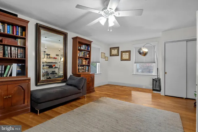 a view of an empty room with wooden floor and closet