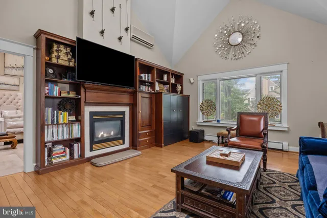 a living room with furniture a bookshelf and a flat screen tv