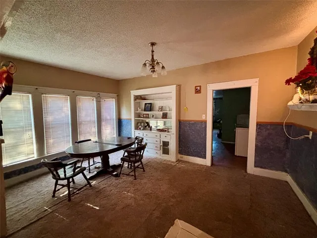 a room with chandelier fan and windows