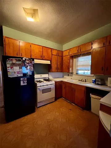 a kitchen with granite countertop a sink cabinets and stainless steel appliances
