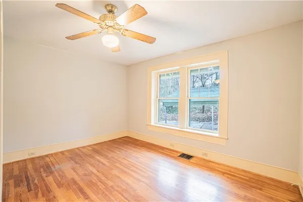 an empty room with a window and a fan