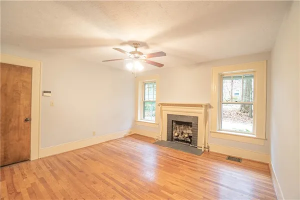 wooden floor fireplace and windows in an empty room
