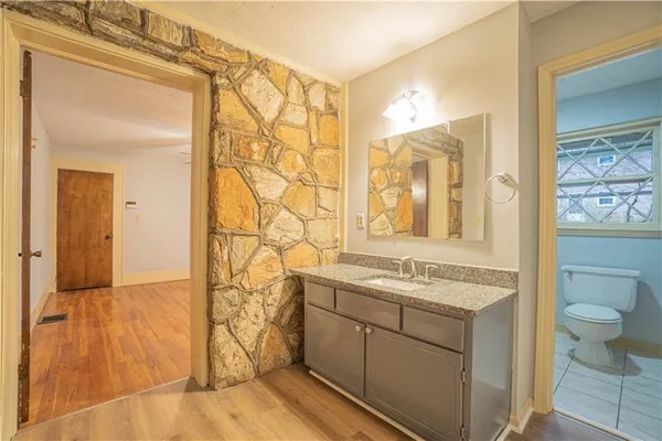 a bathroom with a granite countertop sink a toilet and shower